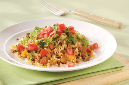 Seasoned rice topped with chopped tomatoes, lettuce, meat and melted cheese